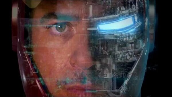 A man’s face blends with a high-tech robot helmet. The left side shows his normal face and eye, while the right side looks like a metal mask with a bright blue eye and visible machine parts.